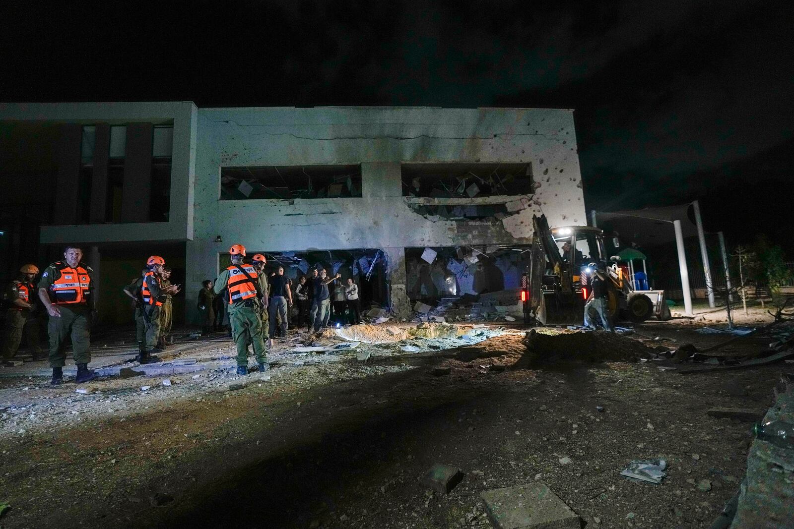 Israeli military and police work at a damaged school building that was hit by missiles fired from Iran in Gadera, Israel, Tuesday, Oct. 1, 2024. (AP Photo/Tsafrir Abayov)