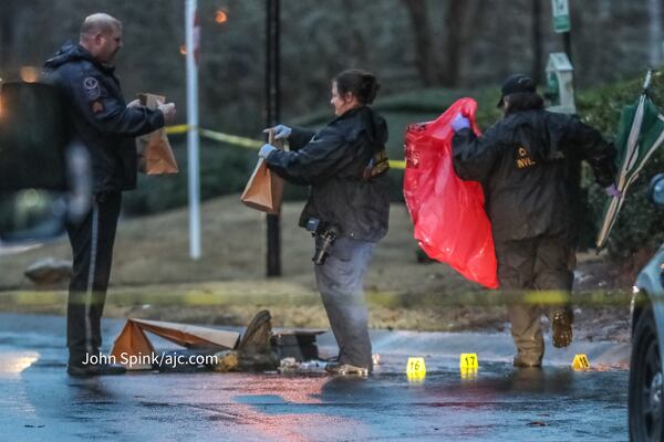 Gwinnett County police collect evidence at the scene Tuesday morning.