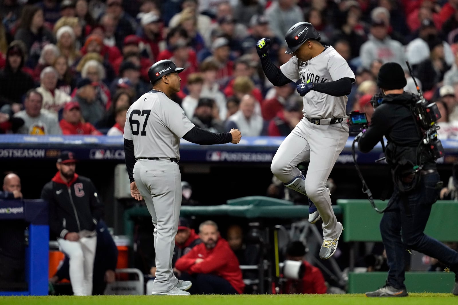 New York Yankees' Juan Soto, right, celebrates with third base coach Luis Rojas (67) after hitting a two-run home run against the Cleveland Guardians during the first inning in Game 4 of the baseball AL Championship Series Friday, Oct. 18, 2024, in Cleveland. (AP Photo/Godofredo A. Vásquez)