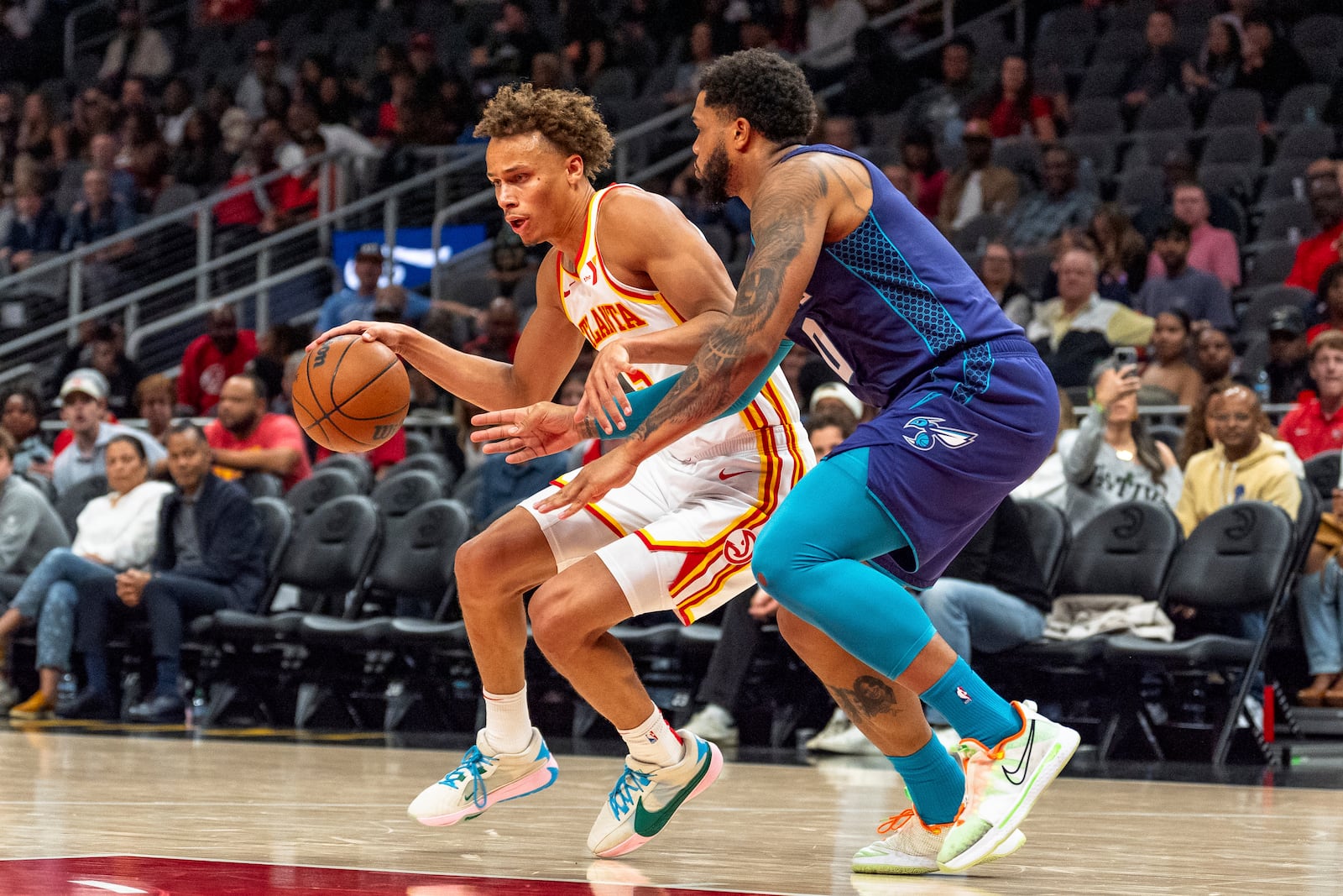 Atlanta Hawks guard Dyson Daniels, left, drives the lane while guarded by Charlotte Hornets forward Miles Bridges, right, during the first half of an NBA basketball game, Friday, Oct. 25, 2024, in Atlanta. (AP Photo/Jason Allen)