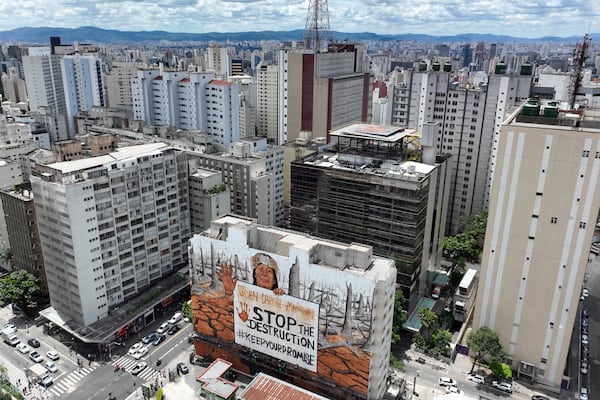 A mural by artist-activist Mundano depicting the drought in the Amazon rainforest using paint made from the ashes of wildfires in the Amazon and mud from the floods in southern Brazil decorate a building in Sao Paulo, Tuesday, Oct. 22, 2024. (AP Photo/Andre Penner)