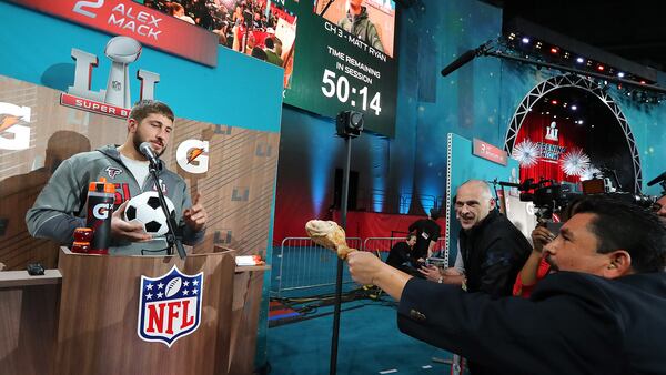 A member of the crowd offers Falcons center Alex Mack a turkey leg during Super Bowl Opening Night on Monday, Jan. 30, 2017, at Minute Maid Park in Houston.