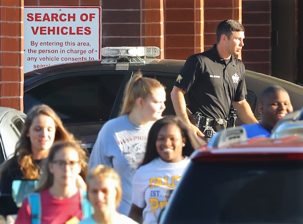 Students pass by a Laurens County Sheriff’s deputy stationed at East Laurens High School on Tuesday, May 2, 2018, in Dublin. Laurens County is the first school district in Georgia to allow teachers and other school personnel to carry weapons. Curtis Compton/ccompton@ajc.com