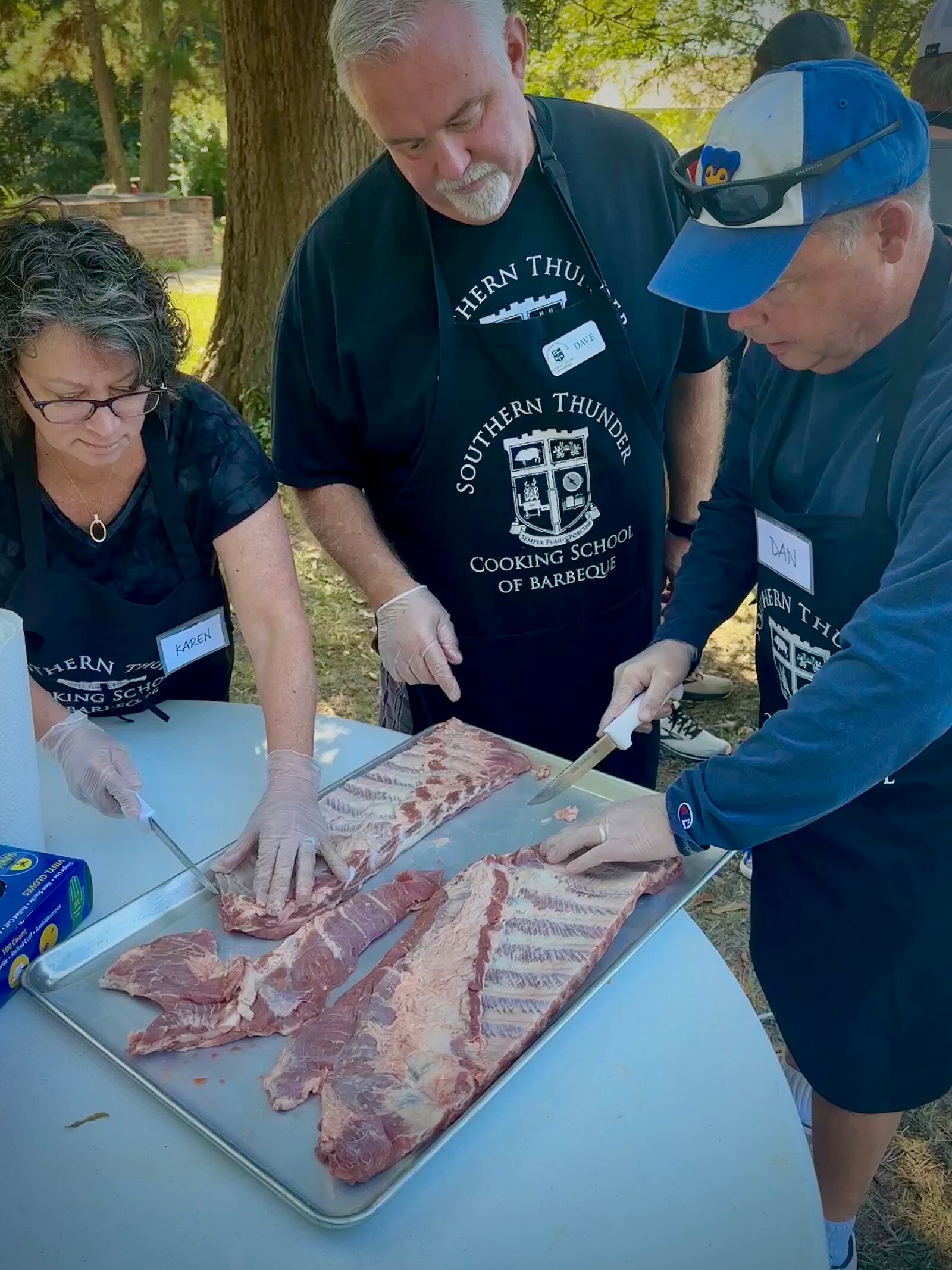 Students learn from co-owner Dave Weiss (center) about how to prepare ribs for the grill. 
Photo: Courtesy of the Southern Thunder BBQ Cooking School