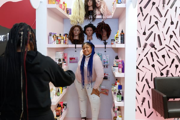 Taylin Cody takes a photo of her daughter Mariana,12, at the Black Hair Experience in Atlanta on Saturday, January 28, 2023.  (Natrice Miller/natrice.miller@ajc.com) 