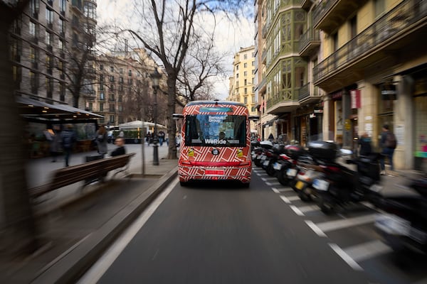 A driverless mini-bus, presented by WeRide and Renault Group, drives along a street in Barcelona downtown, Wednesday, March 12, 2025. Commuters in downtown Barcelona have been able to ride the bus for free this week. There's just one catch: this mini-bus has no one at the wheel. (AP Photo/Emilio Morenatti)