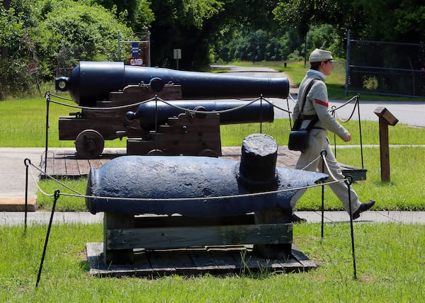 Historical interpreter Cpl. Dianna Jowers walks past cannons recovered from the CSS Georgia ironclad on display in 2013 at Fort Jackson, a National Historic Landmark and the oldest standing brick fort in Georgia on the Savannah River. The wreckage of the ship sat underwater for almost 150 years. Some material, including cannons, were removed by archaeologists decades ago. More recently, more of the wreck and related artifacts were recovered as part of a deepening project for the shipping channel. From back to front are a model 1846 32-pounder and a 24-pound howitzer. Both were mounted on the CSS Georgia during the Civil War. At front is a 10-inch columbiad -- not from the CSS Georgia. Curtis Compton / AJC 