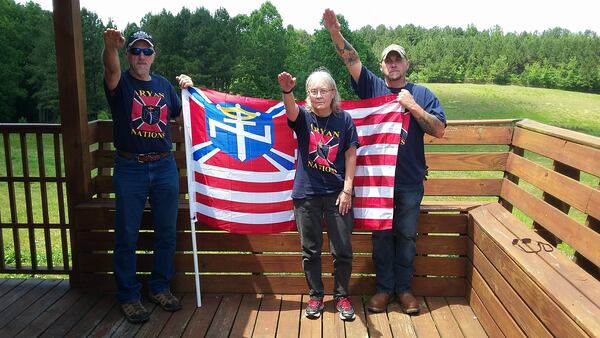 Apparent members of the Ayran Nations Worldwide, a Villa Rica-based extremist group, salutes and poses with their group's flag in a photo from their Facebook page.