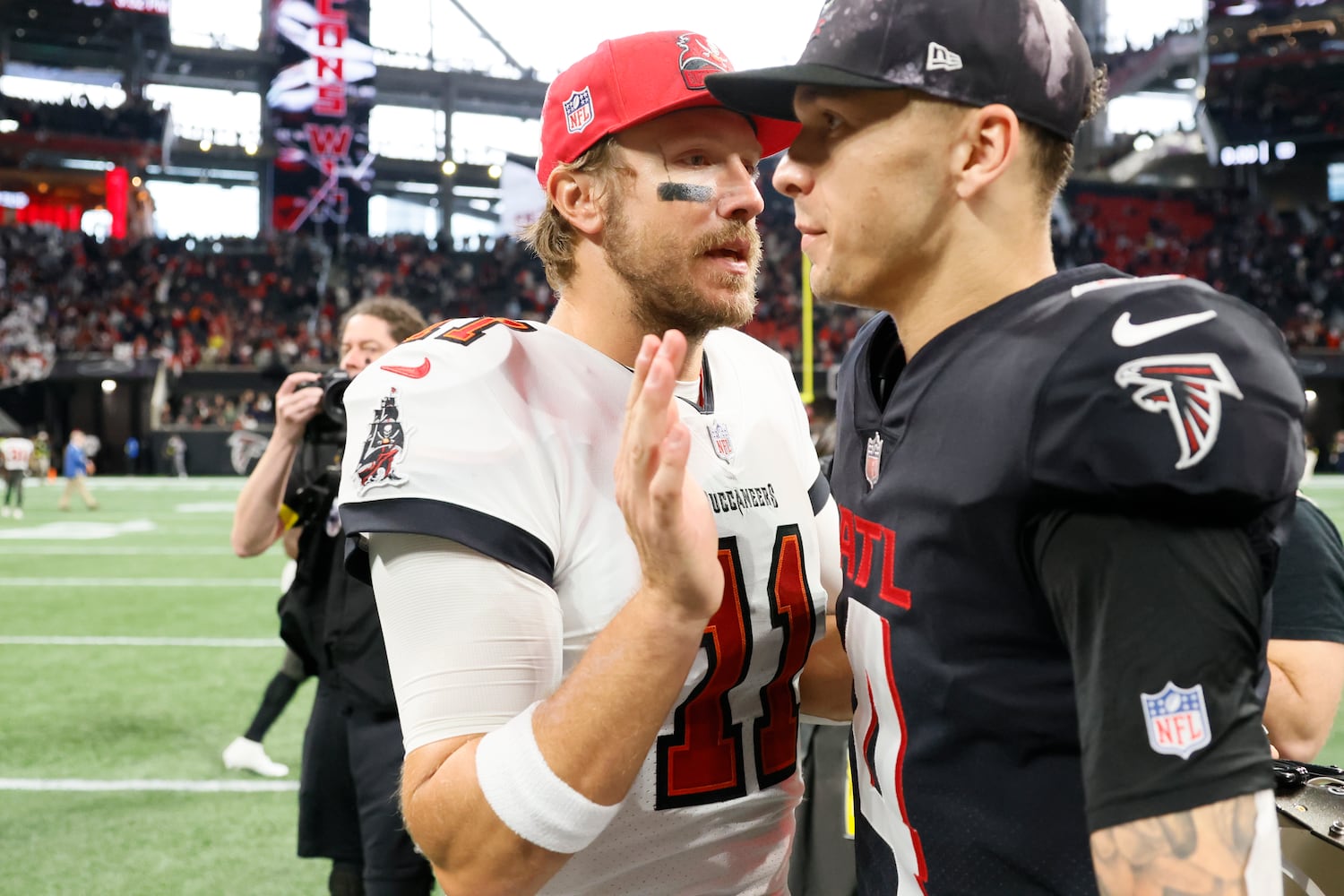 Falcons quarterback Desmond Ridder talks to Buccaneers quarterback Blaine Gabbert after host Atlanta defeated Tampa Bay 30-17 on Sunday. (Miguel Martinez / miguel.martinezjimenez@ajc.com)