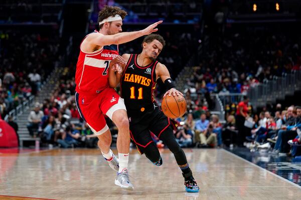 Washington Wizards forward Corey Kispert, left, defends against Atlanta Hawks guard Trae Young during the second half of an NBA basketball game, Friday, March 4, 2022, in Washington. The Hawks won 117-114. (AP Photo/Evan Vucci)