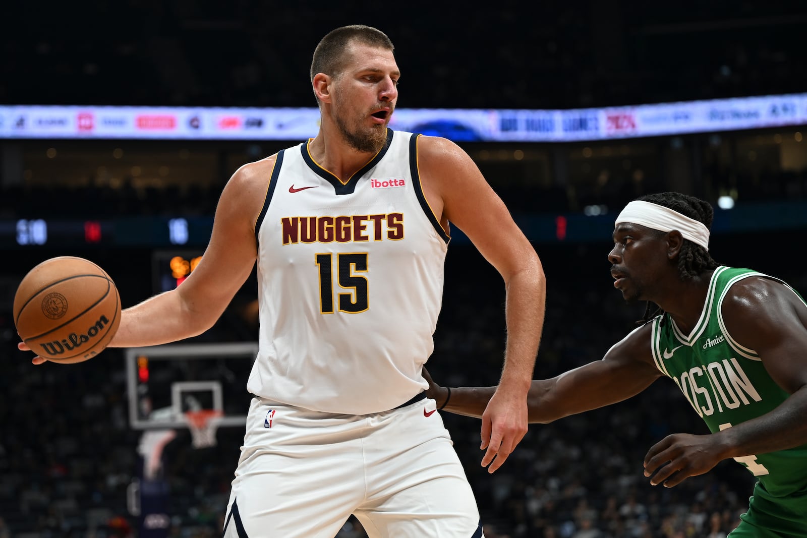 Boston Celtics Jrue Holiday guards Denver Nuggets Nikola Jokic during a preseason game between Boston Celtics and Denver Nuggets in Abu Dhabi, United Arab Emirates, Sunday, Oct. 6, 2024. (AP Photo/Martin Dokoupil)