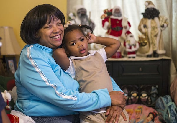 Priscilla Moses, 52, sits with her adopted daughter Karrigan, 2, at their residence in Decatur. Karrigan, who was born to a teenage mom, has been with the Moses sisters since she was 5 days old. They fostered her, then adopted her. 