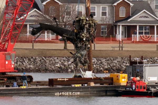 Salvage crews pull up a part of a Black Hawk helicopter near the site in the Potomac River of a mid-air collision between an American Airlines jet and a Black Hawk helicopter at Ronald Reagan Washington National Airport, Thursday, Feb. 6, 2025, in Arlington, Va. (AP Photo/Jose Luis Magana)