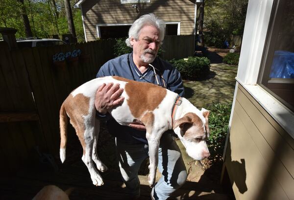 Bob Futterman helps his and his wife’s 14-year-old dog Henry coming up the stairs at their home in Decatur. HYOSUB SHIN / HSHIN@AJC.COM