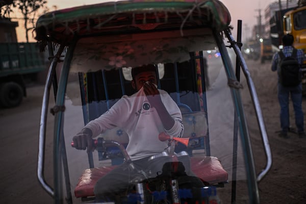 FILE - An auto rickshaw driver covers his face to protect himself from the pollution in Dhaka, Bangladesh, Feb. 9, 2025. (AP Photo/Mahmud Hossain Opu, File)