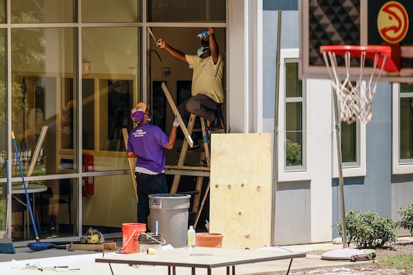 Workers repair a broken window at At-Promise Youth Center on Friday, May 27 2022. (Natrice Miller / natrice.miller@ajc.com)