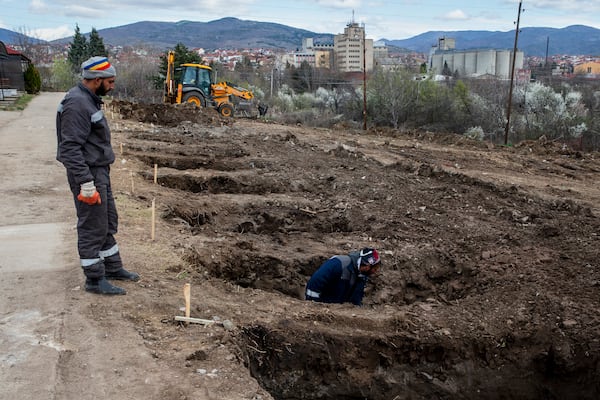 Workers dig graves for the victims of a massive nightclub fire in the town of Kocani, North Macedonia, Tuesday, March 18, 2025. (AP Photo/Visar Kryeziu)