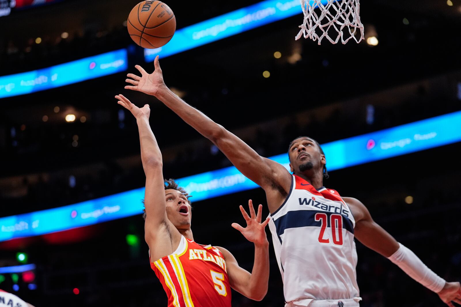 Atlanta Hawks guard Dyson Daniels (5) and Washington Wizards forward Alexandre Sarr (20) reach for a rebound during the first half of an NBA basketball game Monday, Oct. 28, 2024, in Atlanta. (AP Photo/ John Bazemore)