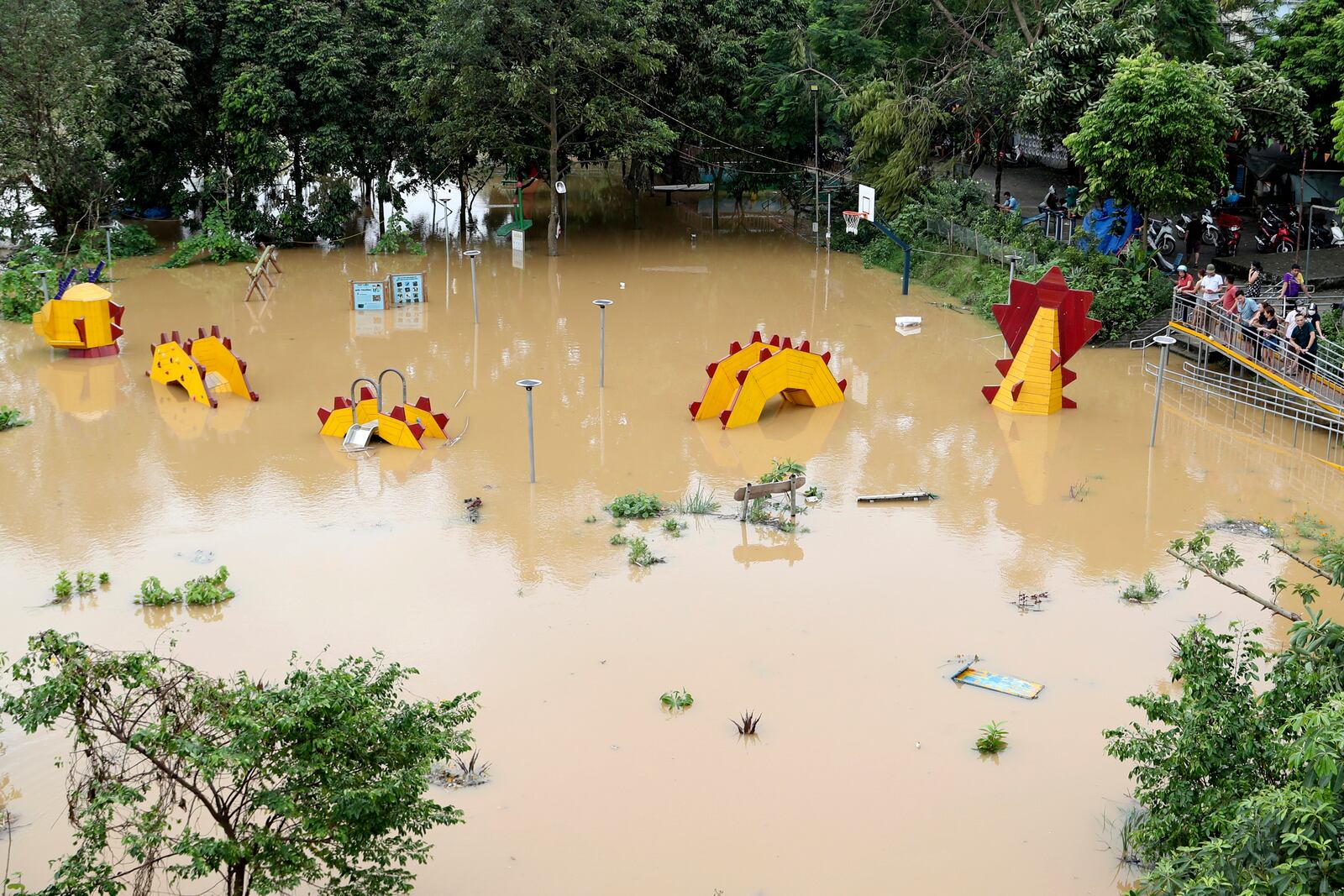 People look on a submerged dragon structure in a playground, following Typhoon Yagi in Hanoi, Vietnam on Tuesday, Sept. 10, 2024. (AP Photo/Huy Han)