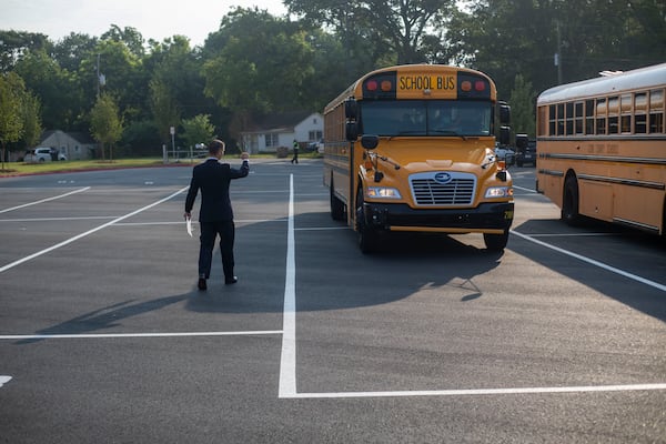  Pearson Middle School Senior Assistant Principal Mitchell Askew directs school busses to their parking spot during the first day of school at Pearson Middle School in Marietta, Monday, August 2, 2021. (Alyssa Pointer/Atlanta Journal Constitution)