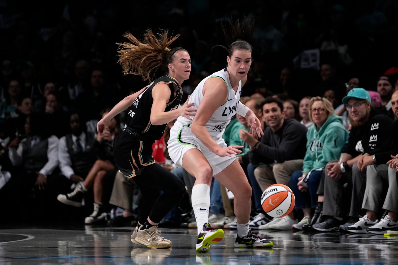 Minnesota Lynx's Bridget Carleton, right, dribbles the ball against New York Liberty's Sabrina Ionescu, left, during the first half in Game 1 of a WNBA basketball final playoff series, Thursday, Oct. 10, 2024, in New York. (AP Photo/Pamela Smith)