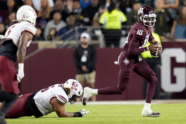 Texas A&M quarterback Marcel Reed (10) scrambles out of the pocket to avoid a sack by New Mexico State defensive tackle Naki Fahina (6) during the first half of an NCAA college football game Saturday, Nov. 16, 2024, in College Station, Texas. (AP Photo/Sam Craft)