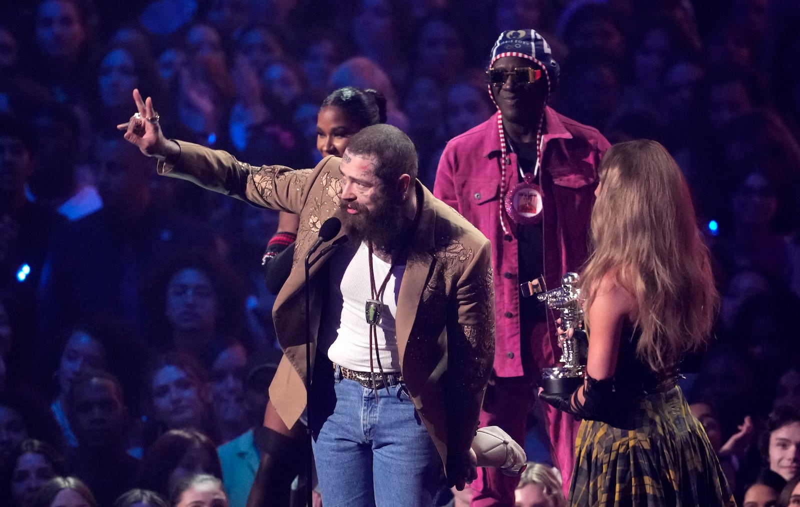 Post Malone, left, and Taylor Swift accept the award for best collaboration for "Fortnight"during the MTV Video Music Awards on Wednesday, Sept. 11, 2024, at UBS Arena in Elmont, N.Y. Jordan Chiles, back left, and Flava Flav look on.(Photo by Charles Sykes/Invision/AP)