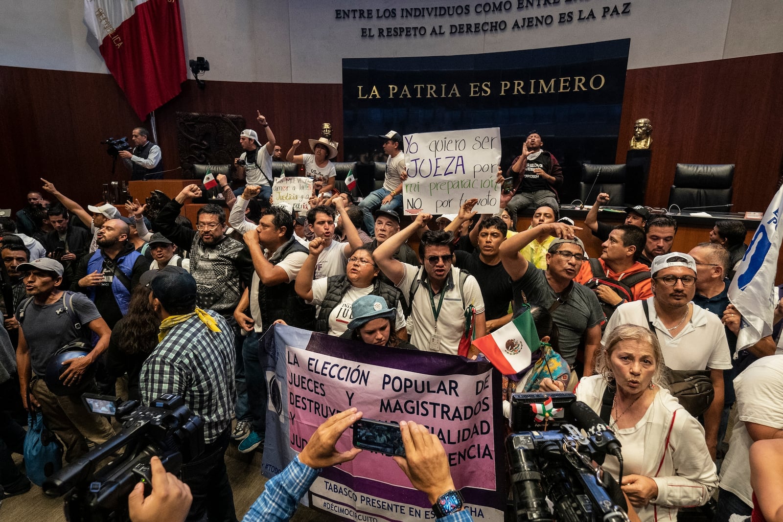 Protesters interrupt a Senate session in which lawmakers were debating the government's proposed judicial reform, which would make judges stand for election, in Mexico City, Tuesday, Sept. 10, 2024. (AP Photo/Felix Marquez)