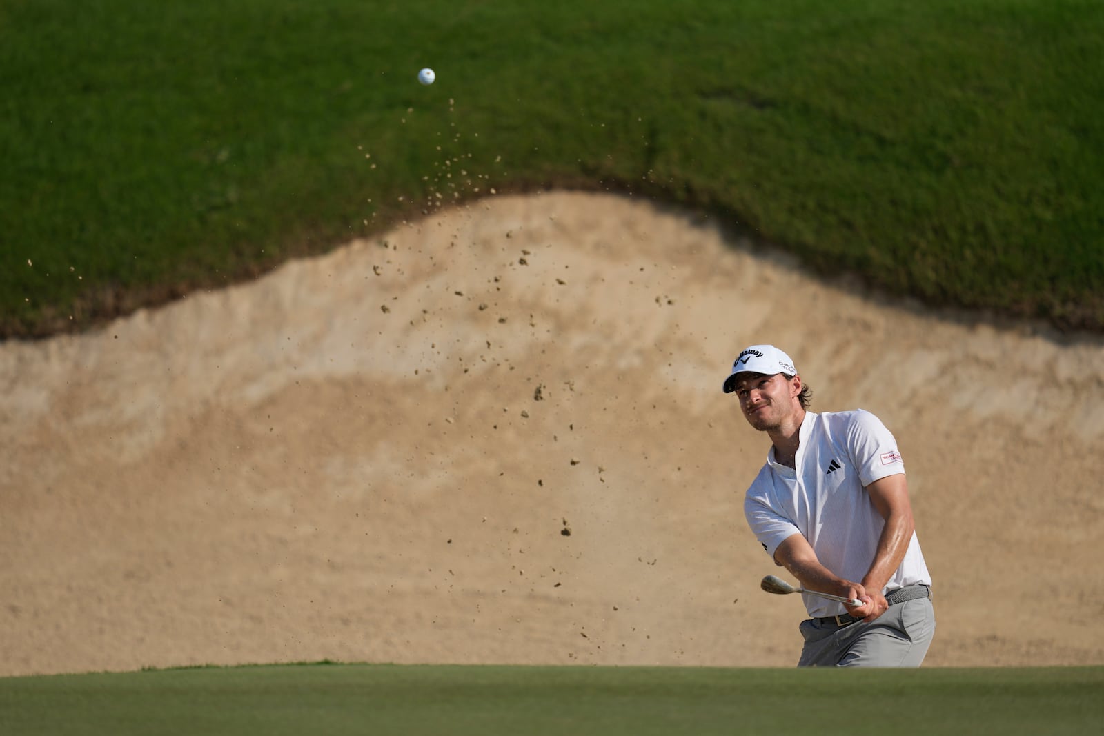 Rasmus Højgaard of Denmark plays his second shot at the 12th hole during the second round of Abu Dhabi Golf Championship in Abu Dhabi, United Arab Emirates, Friday, Nov. 8, 2024. (AP Photo/Altaf Qadri)