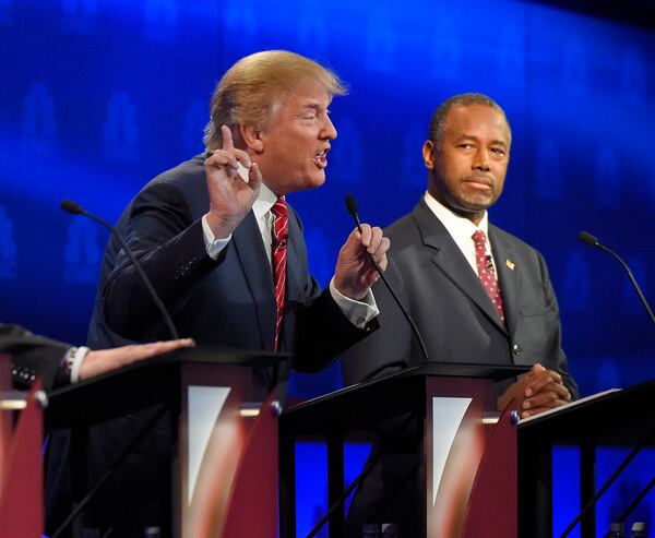 Ben Carson, right, watches as Donald Trump speaks during the CNBC Republican presidential debate at the University of Colorado, Wednesday, Oct. 28, 2015, in Boulder, Colo. (AP Photo/Mark J. Terrill)