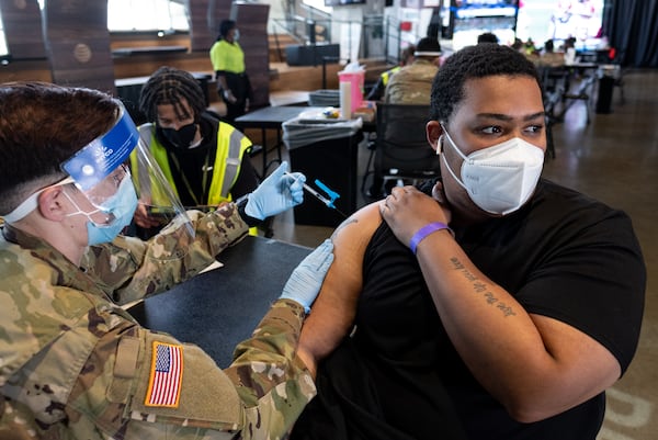 Sgt. Ashley Nazzario administers a COVID-19 vaccine to Ezekiel Dorsey at the mass vaccination site at Mercedes-Benz Stadium on Thursday morning. A pause on the Johnson & Johnson vaccine has been in place since April 13. (Ben Gray for the Atlanta Journal-Constitution)