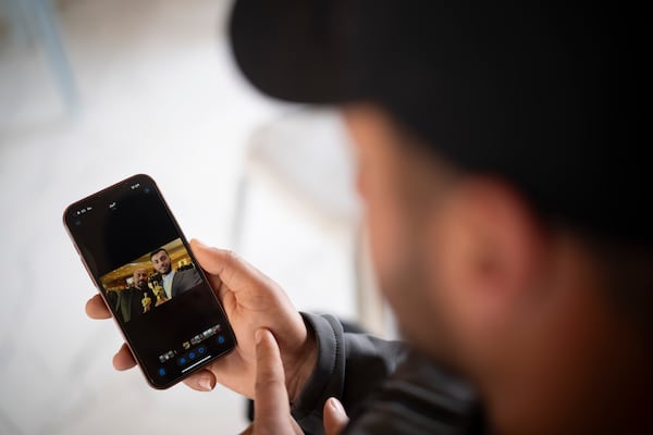 Salem Adra, shows a photo on his mobile phone in the West Bank village of Tuwani, Monday, March 3, 2025, depicting his brother, Palestinian activist Basel Adra, right, and Hamdan Ballal after they have been awarded Best Documentary Feature at the Oscars for "No Other Land". (AP Photo/Leo Correa)