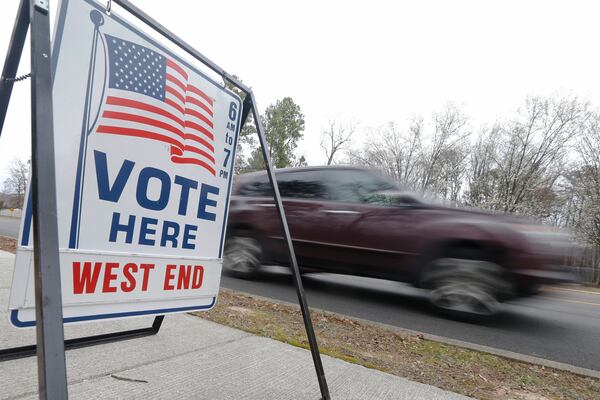 A car passes a polling precinct during the Democratic Presidential primary voting Tuesday, March 3, 2020, in Richmond, Va. (AP Photo/Steve Helber)