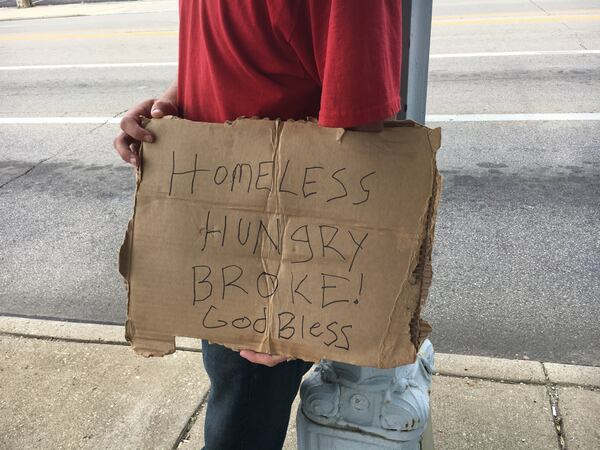 Kyle holds up his sign at Patterson Boulevard and Jefferson Street. He is staying at the men’s shelter, he said, and trying to get the documentation he needs for a job. “There’s too many of us for the system to handle right now. They don’t got enough caseworkers,” he said.