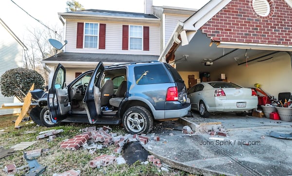 A blue Ford SUV was stolen a short time before the driver crashed into the front of this Browns Mill Ferry Home. JOHN SPINK / JSPINK@AJC.COM