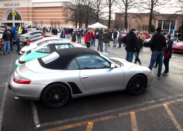 People look over the cars at the Caffeine and Octane car show at Perimeter Mall in Dunwoody on Sunday, February 7, 2021. (Photo: Steve Schaefer for The Atlanta Journal-Constitution)