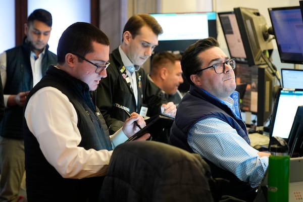 People work on the floor at the New York Stock Exchange in New York, Monday, Feb. 24, 2025. (AP Photo/Seth Wenig)