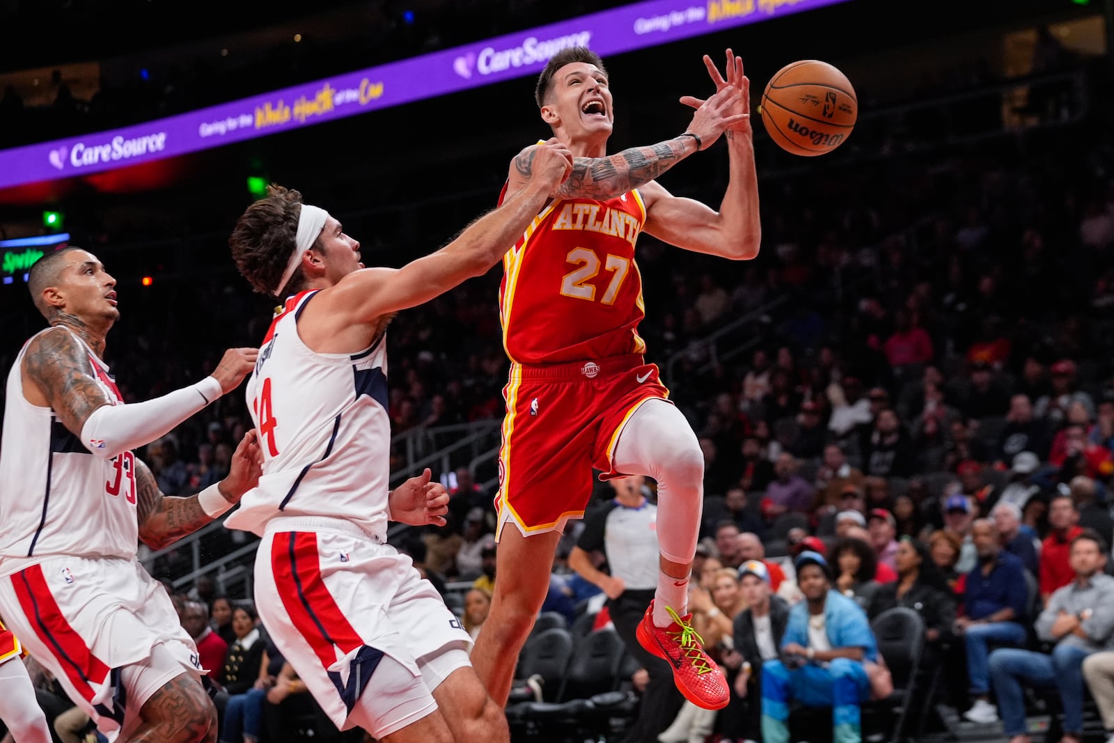 Atlanta Hawks guard Vit Krejci (27) is fouled by Washington Wizards forward Corey Kispert (24) as he drives to the basket during the first half of an NBA basketball game Monday, Oct. 28, 2024, in Atlanta. (AP Photo/ John Bazemore)