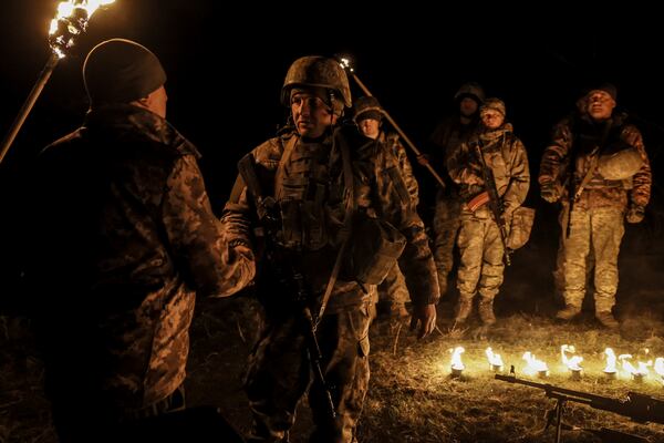 In this photo taken on March 21, 2025 and provided by Ukraine's 24th Mechanized Brigade press service on March 24, 2025, servicemen attend a dedication ceremony for soldiers near the frontline in the Donetsk region, Ukraine. (Oleg Petrasiuk/Ukraine's 24th Mechanized Brigade via AP)