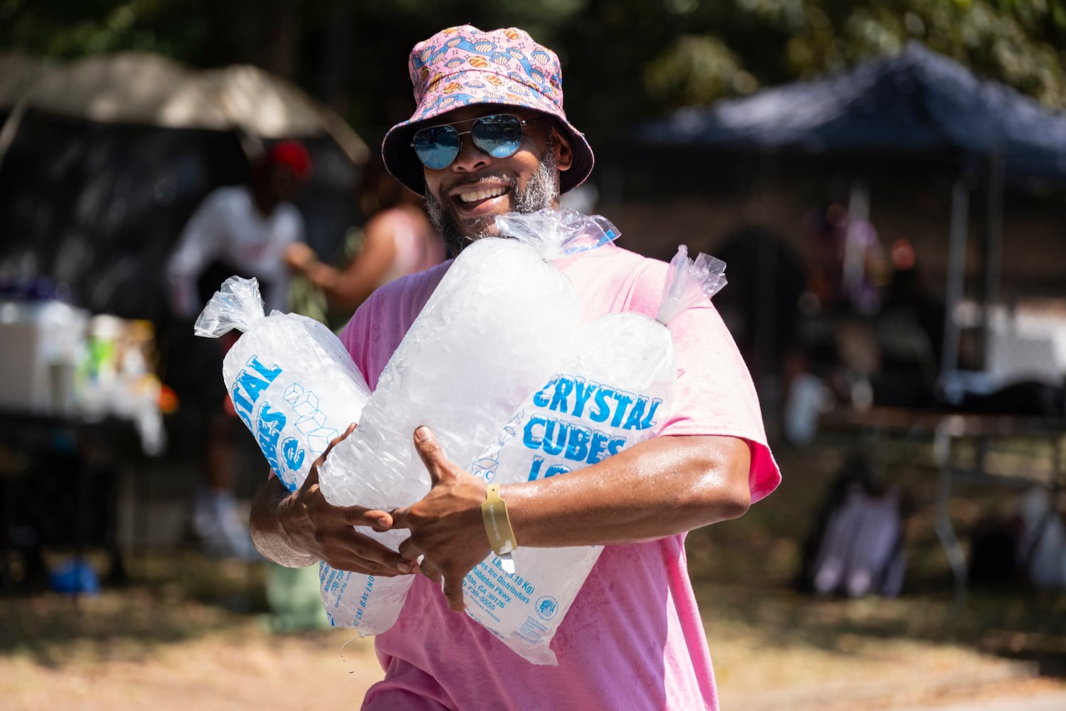 Carlos Turbee has the cool job of carrying bags of ice for him and his friends as they enjoy the 20th anniversary of the House In The Park music festival at Grant Park in Atlanta on Sunday, Sept. 1, 2024. (Ben Gray / Ben@BenGray.com)