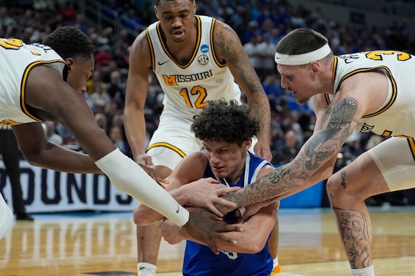 Missouri guard Mark Mitchell, left, and Missouri guard Jacob Crews, right, try to steal the ball from Drake guard Isaia Howard, center, during the first half of the first round of the NCAA college basketball tournament, Thursday, March 20, 2025, in Wichita, Kan. (AP Photo/Charlie Riedel)