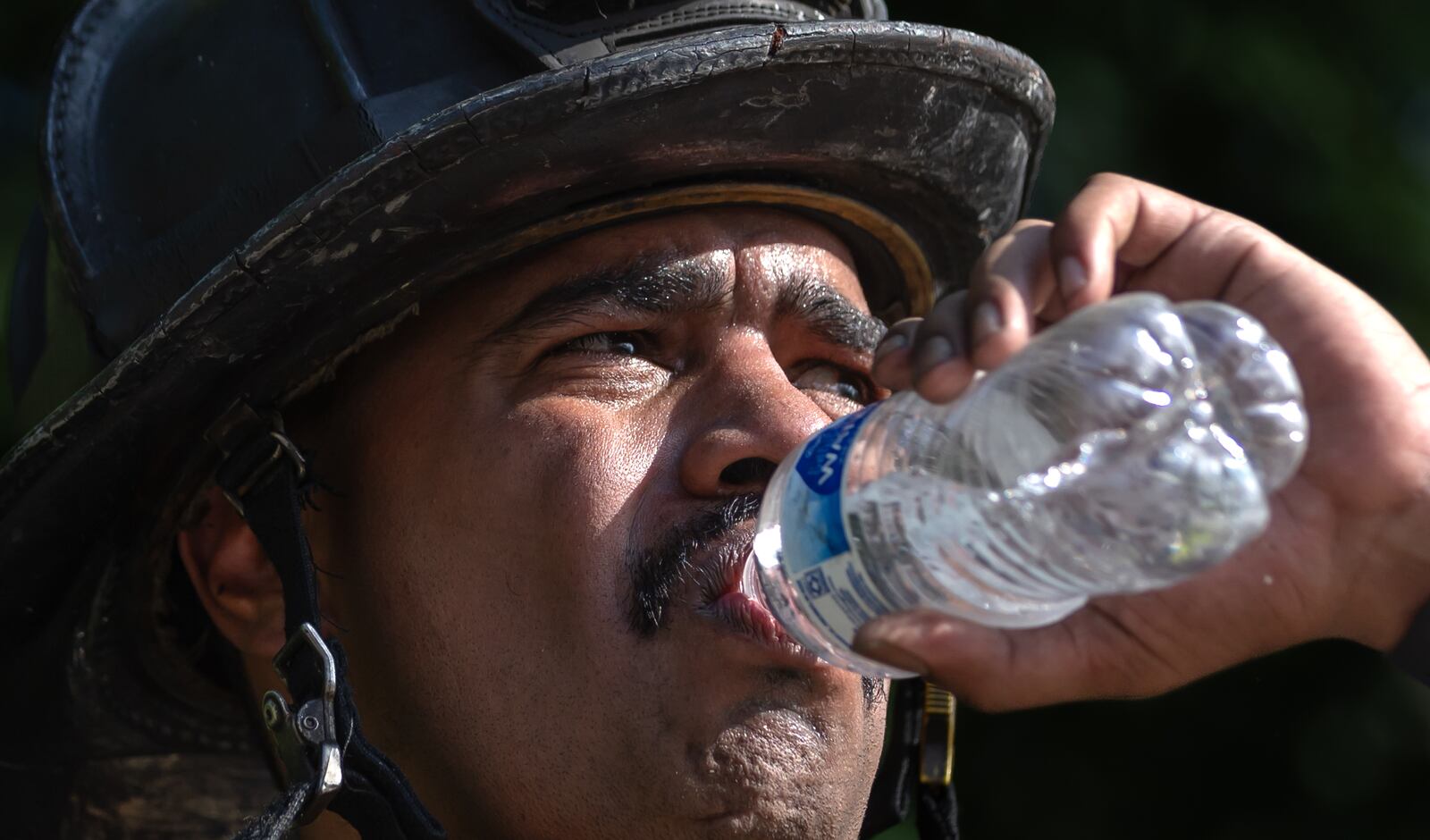 Atlanta firefighter, Darryl  Sharma cools down after operating the aerial ladder of Truck One in the heat. Atlanta firefighters went to it Thursday morning, June 13, 2024, battling a blaze at Morris Brown College for the second time in the past 16 months at the historic building formerly known as Gaines Hall. (John Spink/AJC)