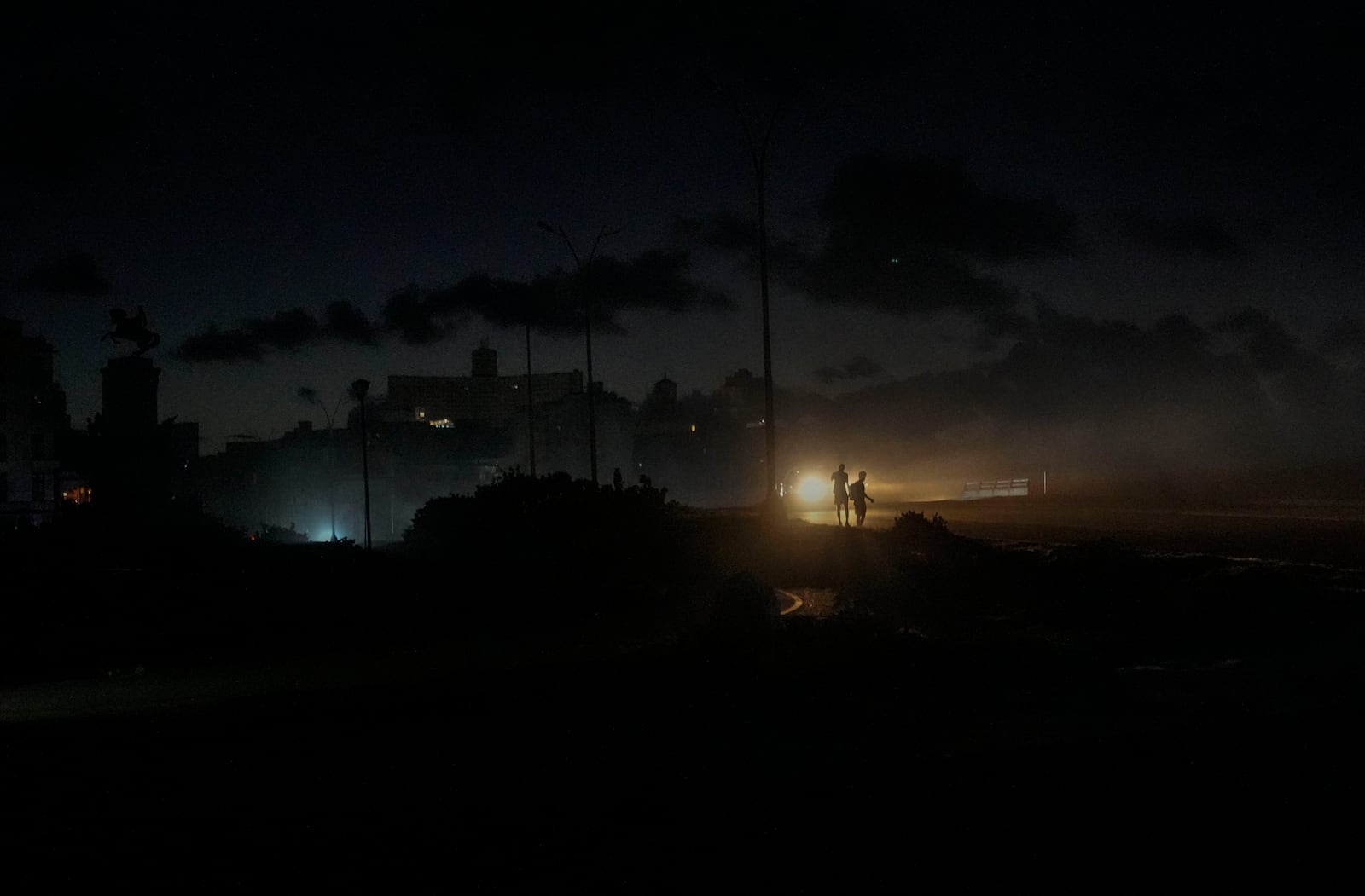 Residents walk on a street during a blackout following the failure of a major power plant in Havana, Cuba, Sunday, Oct. 20, 2024. (AP Photo/Ramon Espinosa)