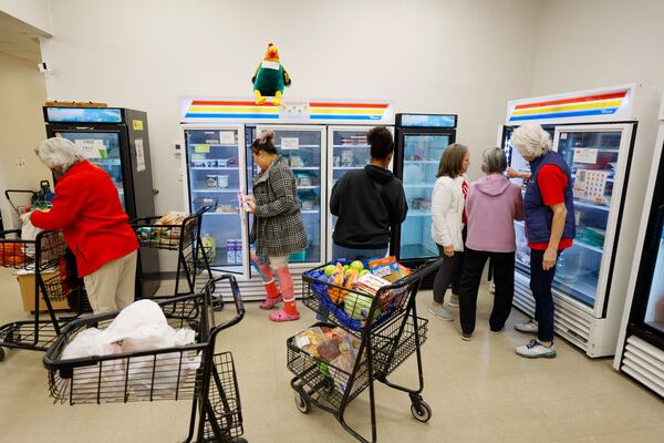 Volunteers help clients pick up food at the Mini-Market in the Community Assistance Center in Roswell; The Community Assistance Center's pantry food program serves the community to help with their food needs. Tuesday, Nov. 14, 2023. Miguel Martinez /

Miguel Martinez /miguel.martinezjimenez@ajc.com