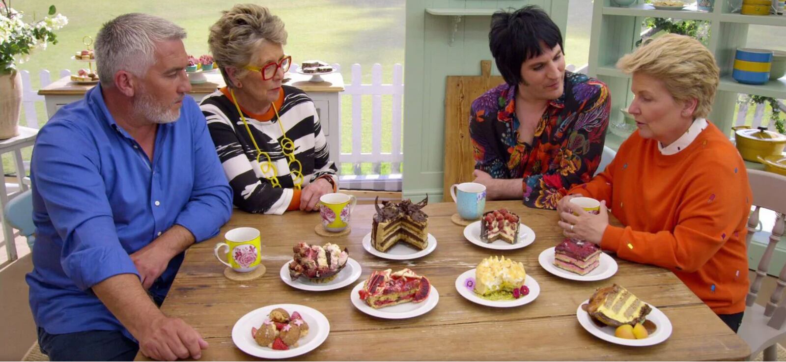 “The Great British Baking Show” has had a changing cast, in addition to judge Paul Hollywood (left). Here, he’s seen with judge Prue Leith and hosts Noel Fielding and Sandi Toksvig. (Courtesy of Netflix)