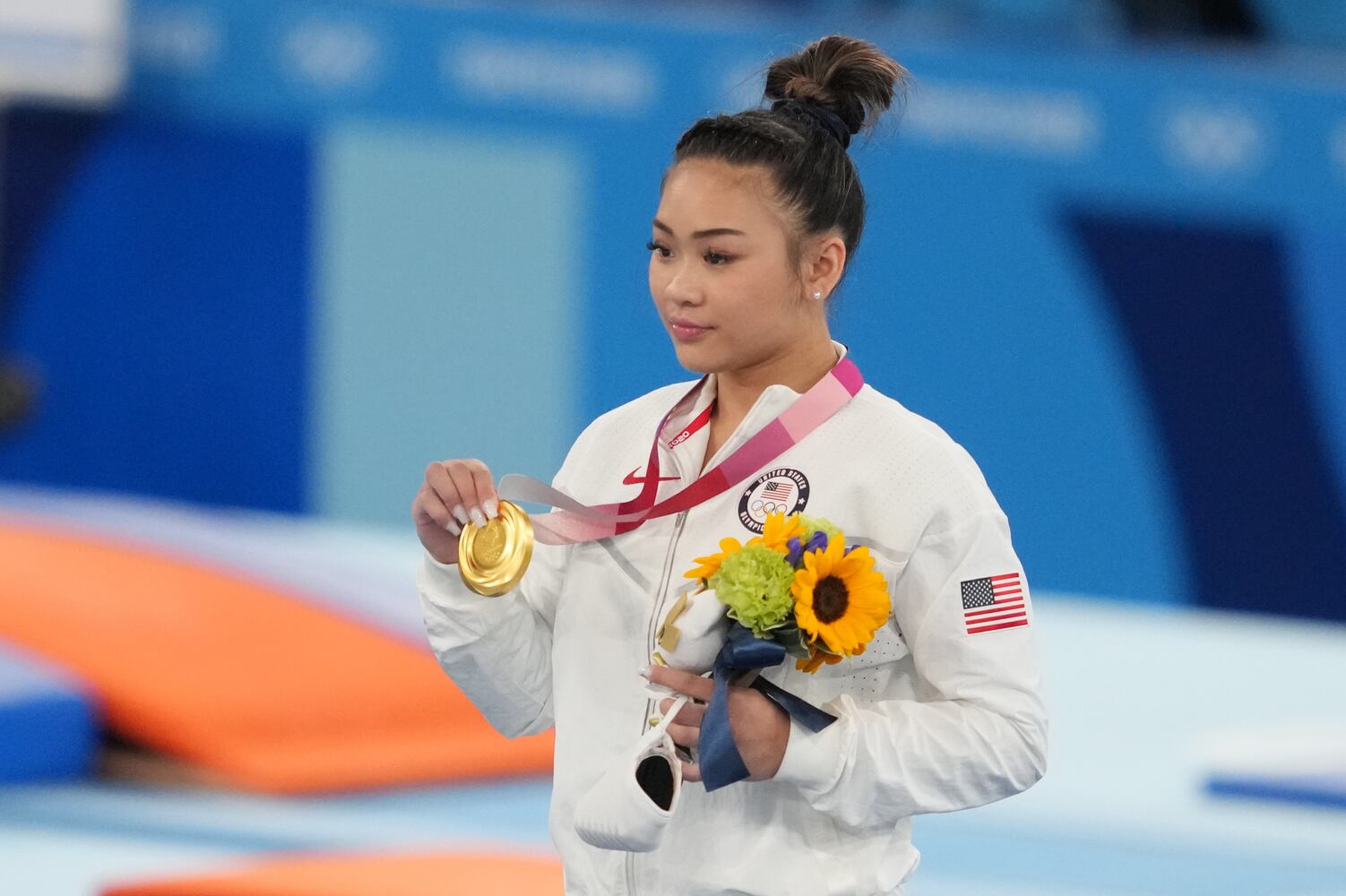 Sunisa Lee of the United States displays her gold medal for  women's all-around gymnastics at the postponed 2020 Tokyo Olympics in Tokyo on Thursday, July 29, 2021. (Chang W. Lee/The New York Times)