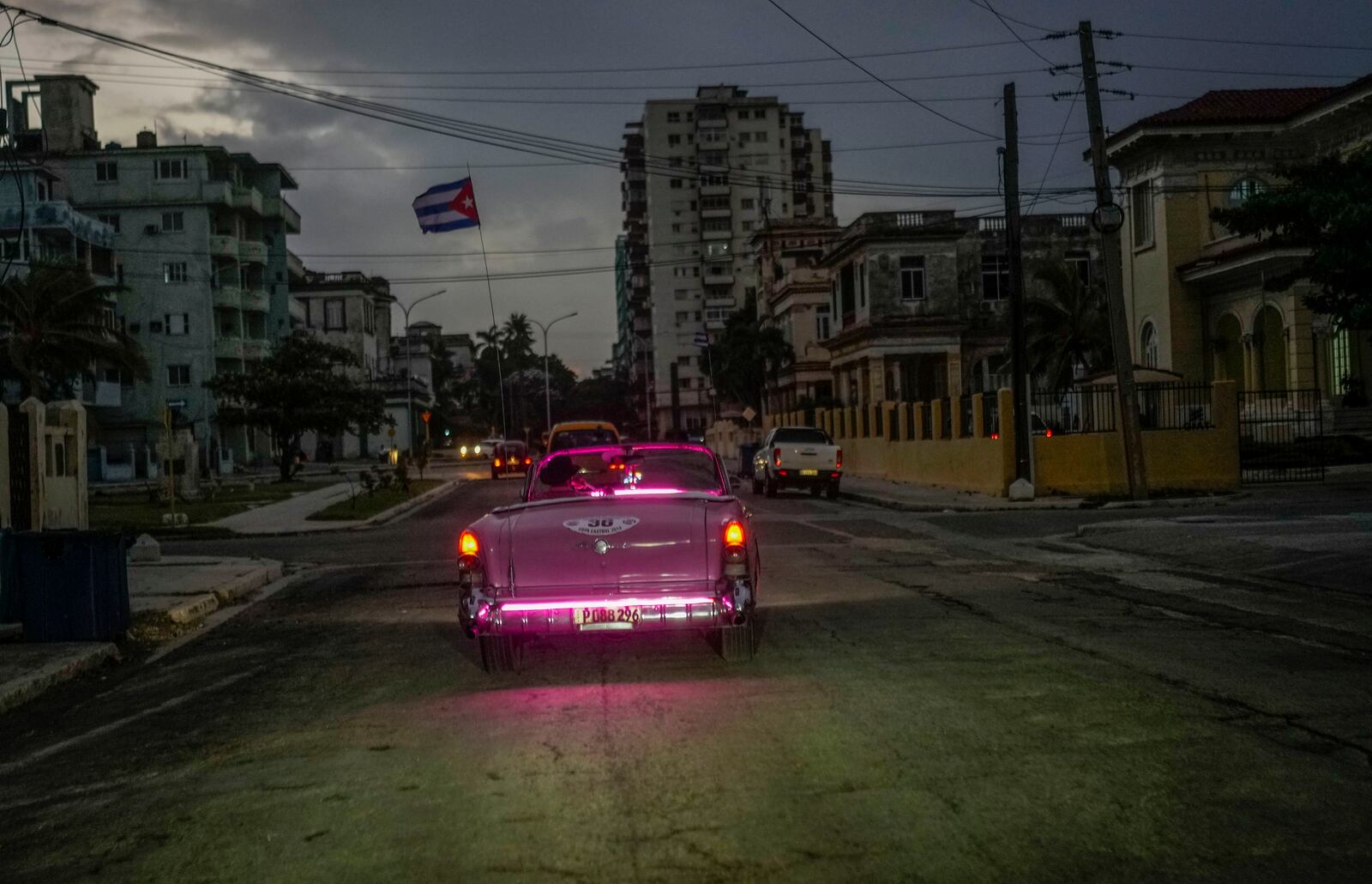 FILE - A classic American car with a Cuban flag drives down a street in Havana, Oct. 21, 2024. (AP Photo/Ramon Espinosa, File)