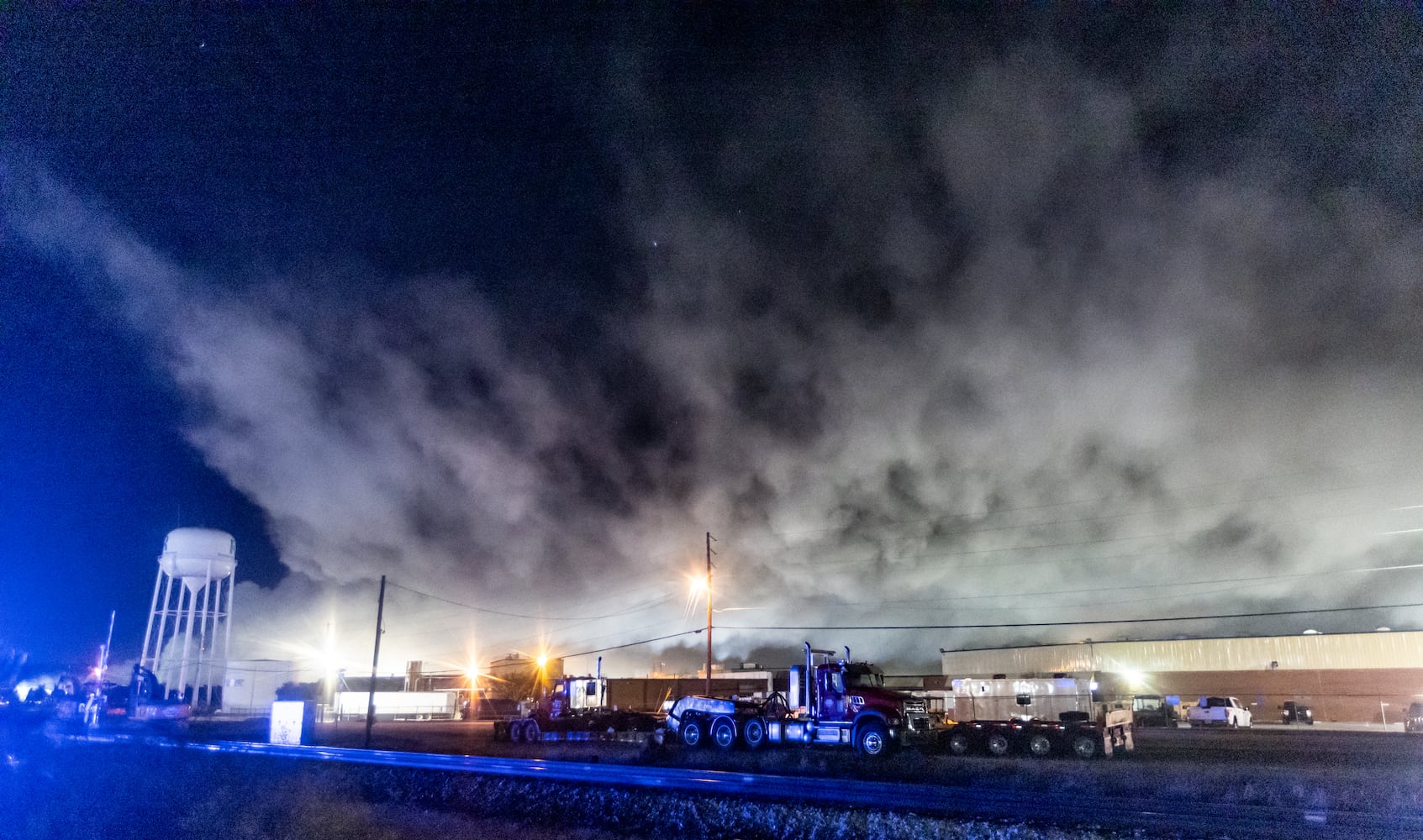 The plume of smoke rising from BioLab as seen from Old Covington Hwy continued on Thursday, Oct. 3, 2024 in Conyers. A Sunday fire at the chemical plant in Conyers has had agencies monitoring the air quality since then as crews try to neutralize the site. Rockdale County officials said that the plume is changing colors as workers remove debris. GEMA has advised anyone who notices a chlorine odor in the air to limit their time outdoors. (John Spink/AJC)