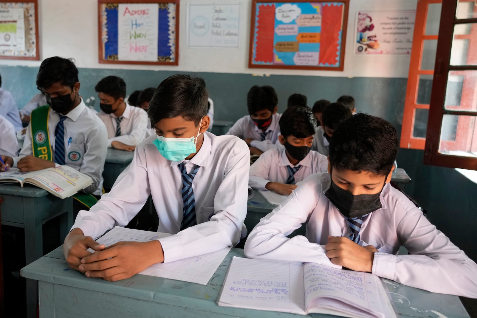 Students wear mask to protect themselves from poor air quality due to increasing smog in the city as they attend their school, in Lahore, Pakistan, Monday, Nov. 4, 2024. (AP Photo/K.M. Chaudary)