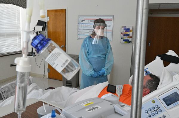 In this file photo, registered ICU nurse Katie Van Hook checks on a COVID-19 patient at Memorial Health's Heart and Vascular Institute in Savannah. (Hyosub Shin / Hyosub.Shin@ajc.com)